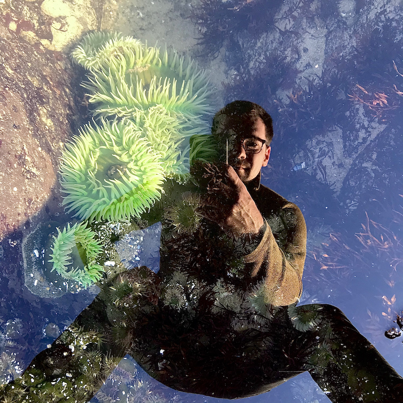 Photograph of tide pool with image of Vince reflecting back.